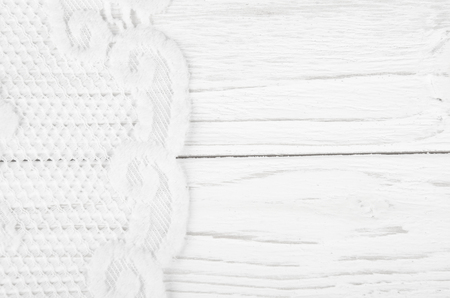 White lace on a worn white wooden background with copyspace on the right (as a vintage background)の写真素材