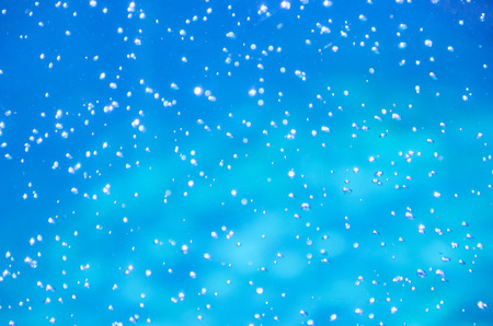 Out-of-focus tiny air bubbles in bright blue water (as an abstract blurred water background)の写真素材