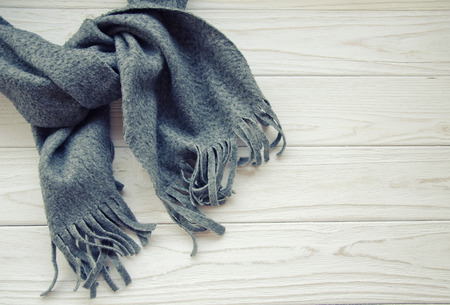 Gray scarf tied up on a wooden background, top view or flat-lay (with copy space on the right), retro styleの写真素材