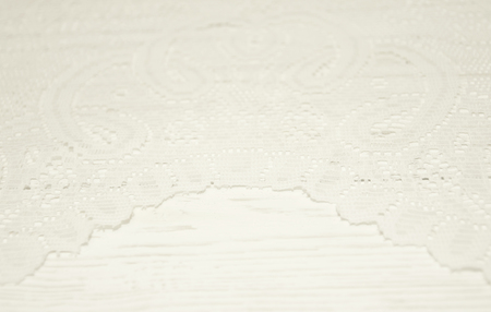 White lace on a worn white wooden background with copy space, selective focus (as a vintage background), retro styleの写真素材