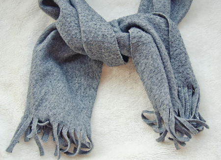 Gray scarf tied up on a white fur background, top view (retro style)の写真素材