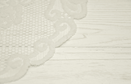 White lace on a worn white wooden background with copy space on the right, selective focus (as a vintage background), retro styleの写真素材