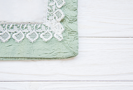 Table cover decorated with white lace (on a white wooden background), copy space on the rightの写真素材