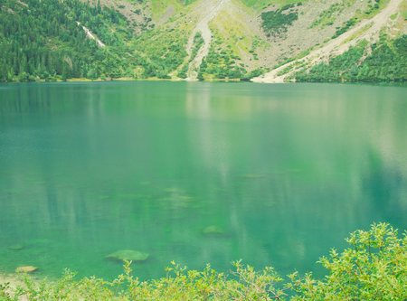 Beautiful mountain lake (Morskie Oko or Sea Eye lake in the Tatra National Park, border of Slovakia and Poland), selective focus on the foregroundの写真素材