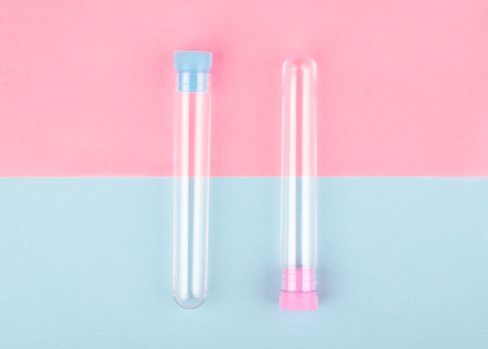 Two empty test tubes on a pink and blue paper background (minimal concept, top view)の写真素材