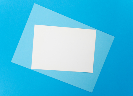 Blank white card on a blue paper backgroundの写真素材