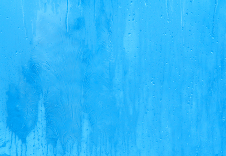 Bright blue frost pattern on the window glass (as an abstract New Year or winter background)の写真素材
