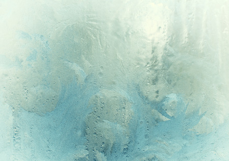 Fantastic fairy-like frost pattern on the window glass (as an abstract winter background), retro tonedの写真素材