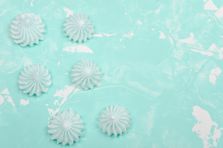 Meringue cookies of mint color on a concrete or marble background (minimal concept), top view, copy space on the rightの写真素材