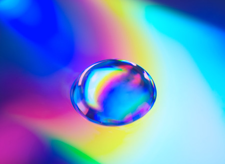Soft focus blurred drop of water in neon colors (against a neon background) as an abstract background, very shallow DOFの写真素材