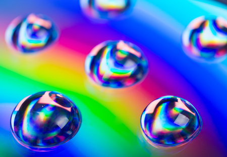 Soft focus blurred drops of liquid in neon colors (against a neon background) as an abstract background, shallow DOF, selective focus on one of the dropsの写真素材