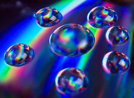Soft focus blurred drops of liquid in neon colors (against a neon background) as an abstract background, shallow DOF, selective focus on one of the dropsの写真素材