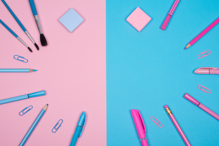 School supplies of pink and blue colors on the pink and blue background, copy space for your text (minimal concept)の写真素材
