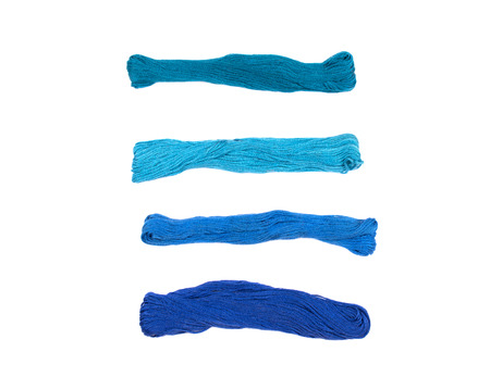 Set of embroidery threads of different shades of blue color (isolated on white)の写真素材