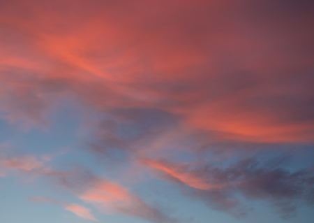 Dramatic sunset sky with rays of sunlight in bright orange clouds (as an abstract background)の写真素材