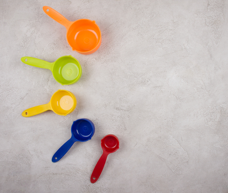 Set of colorful measuring spoons on a gray marble background (top view, copy space for your text)の写真素材