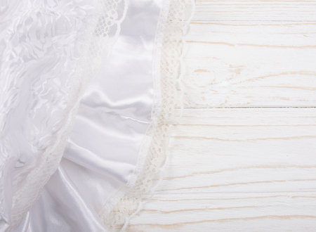 White silk and lace against a white wooden background (top view, copy space on the right for your text)の写真素材