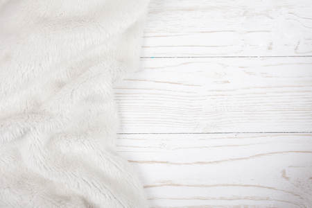 White fur on a worn white wooden background (top view, copy space on the right), selective focusの写真素材