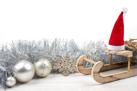Christmas or New Year decorations (wooden toy Christmas sleigh with a Santa hat, silver tinsel,...