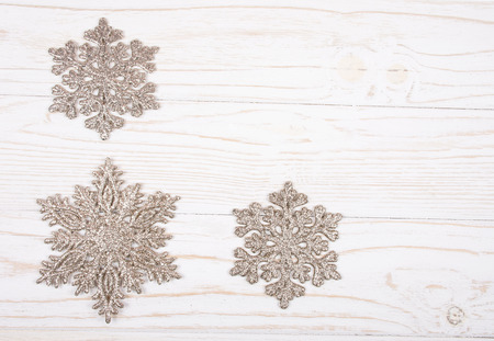 Snowflakes as Christmas decorations on a white wooden background (top view, copy space for your text)の写真素材