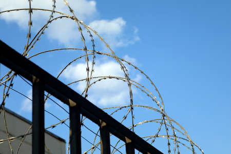 barbed wire fence of security or forbidden guarded area zone, freedom concept with space for your textの写真素材