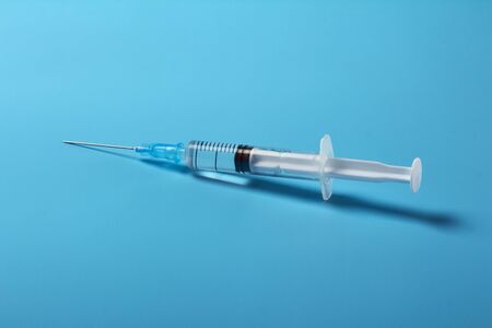 The syringe with the vaccine on  blueの写真素材