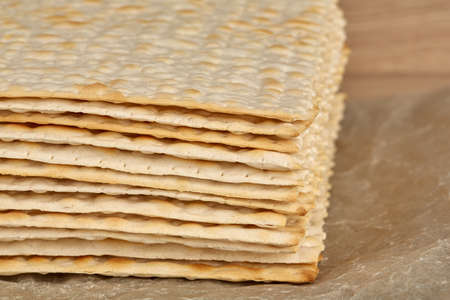 Traditional Jewish kosher matzo for Passover. Peach celebration. The banner. Matza is lying on a wooden tableの写真素材