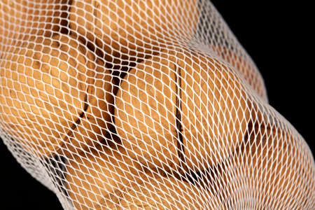 Walnuts in a white packaging grid on a black background, close-up photo