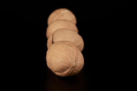 Walnuts lined up one after another on a black backgroundの写真素材