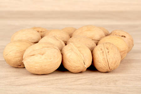 Many walnuts lie in a heap on a wooden backgroundの写真素材
