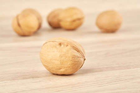 Walnuts on a wooden background, one nut in the foregroundの写真素材