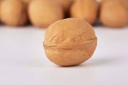 Walnuts on a white background, one nut in the foregroundの写真素材