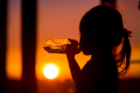 little girl drinks mineral waterの写真素材