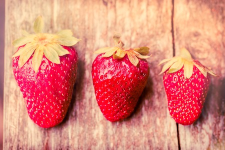 three strawberries on the table. Toned imageの写真素材