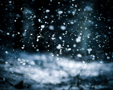 Detail of softly falling snowflakes in the nightly sky.の写真素材