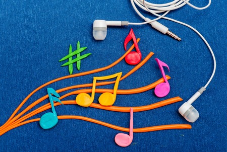 Abstract Music Background with Notes and white headphones. Plasticine modeling.