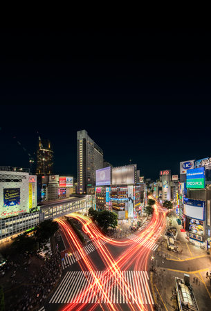 Aerial view of the Shibuya Crossing Intersection in front of Shibuya Station on a summer night with the speed lights flow of cars.のeditorial素材