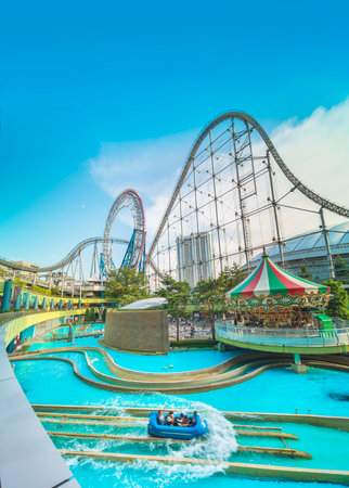 Laqua Tokyo Dome City Mall with its impressive roller coaster integrated in the gallery of its shopping center with a carousel  and water coaster under the summer blue sky.のeditorial素材