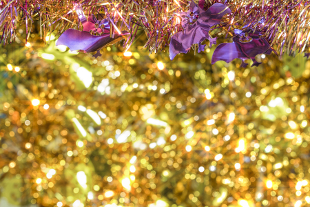 Background texture full of golden bokeh with garlands decorated of purple smiling bats faces in foreground to celebrate the halloween party.の写真素材