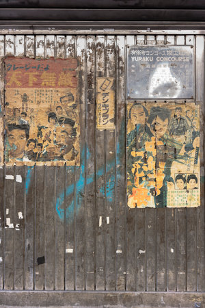 Old vintage retro japanese movie posters on underpass Yurakucho Concourse wall under the railway line of the station Yurakucho. Japanese noodle stalls and sake bars revive the nostalgic years of Showa air with old samurai posters and placards glued to theのeditorial素材