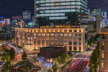 Night view of KITTE commercial facility building deployed by Japan Post in 2013, The GranTokyo and Pacific Century Place Marunouchi skyscrapers overlooking the railroad tracks of Tokyo Station. The GranTokyo building, whose first 14 storeys are occupied bのeditorial素材