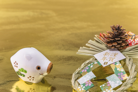 Japanese New Year's Cards with handwriting ideograms Gingashinnen which means Happy New Year with cute Zodiac animal figurine of boar or pig and pine cone on traditional ornament on golden background.の写真素材