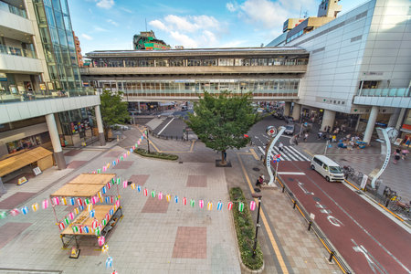 View of the square in front of the Nippori train station decorated for the Obon festival in the summer with a yagura tower and paper lanterns in the Arakawa district of Tokyoのeditorial素材