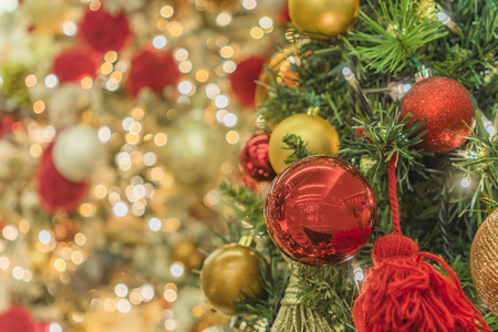 Blur bokeh background of Christmas tree ornament lights with glitter decoration balls in foreground.の写真素材