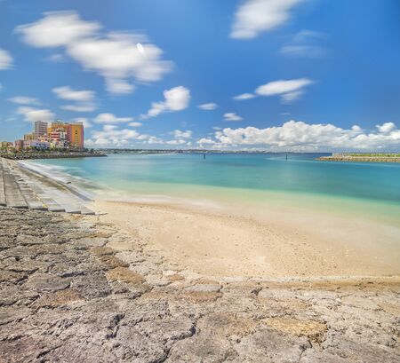 Beach coast lined with palm trees of Distortion Seaside, Oak fashion, Depot Island Seaside buildings and Vessel Hotel Campana in the vicinity of the American Village in Chatan City of Okinawa.の写真素材