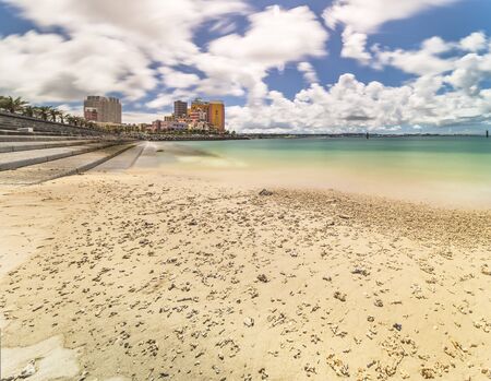 Beach coast lined with palm trees of Distortion Seaside, Oak fashion, Depot Island Seaside buildings and Vessel Hotel Campana in the vicinity of the American Village in Chatan City of Okinawa.の写真素材