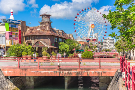 American Village, Japan - September 17, 2018: Chatan City Red Steel Bridge and Mihama Carnival Park Ferris wheel in the American Villageのeditorial素材