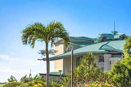 GINOWAN, JAPAN - September 16 2018: Building of Okinawa Convention Center decorated with palm trees near the tropical beach of Ginowan Cityのeditorial素材