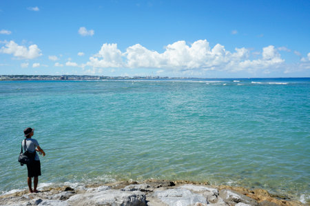 Okinawa, Japan - September 14, 2018: Man fishing at the beach in Chatan City in Okinawa island, Japan.のeditorial素材