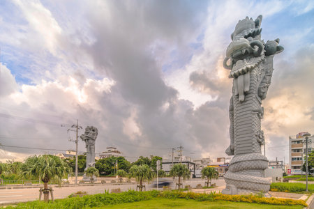Naha, Japan - September 15, 2018: Sunrise on the giant stone dragon head of the pillars that greet the ship Naha Harbor Cruise Terminal dock, Naha and Fuzhou symbol of sister cities in China.のeditorial素材